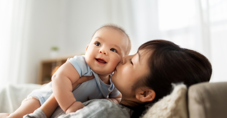 Mom kissing happy baby boy