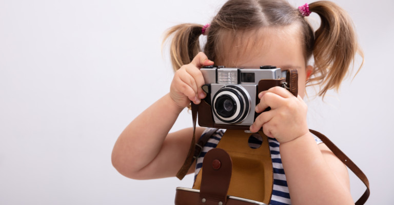 little girl holding camera