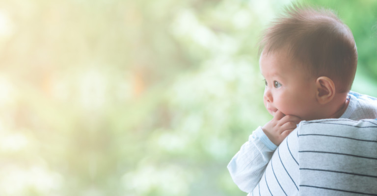 little boy looking over mom's shoulder