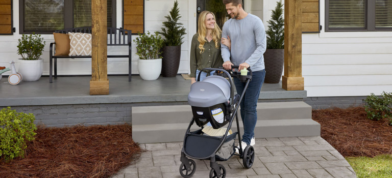 Parents going for a stroll with their infant in a Willow Brook S+ Travel System in Graphite Onyx, Parent Facing Mode