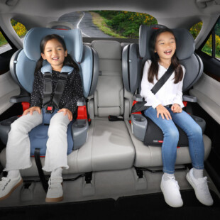 A child in car seat and a child in a booster seat.