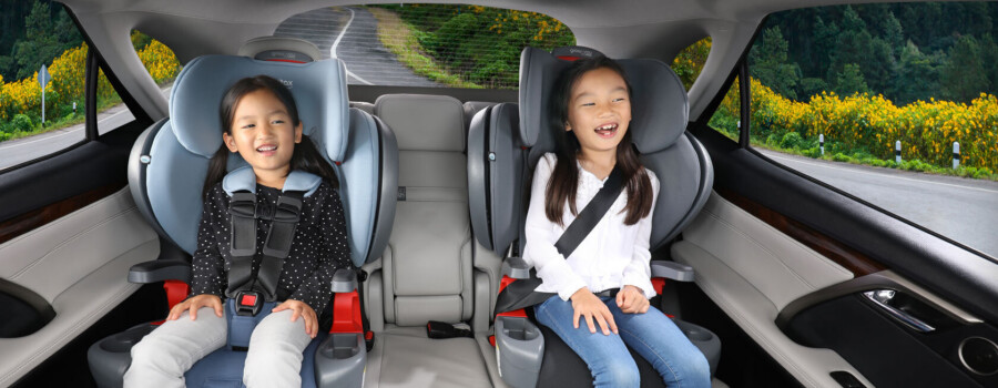A child in car seat and a child in a booster seat.