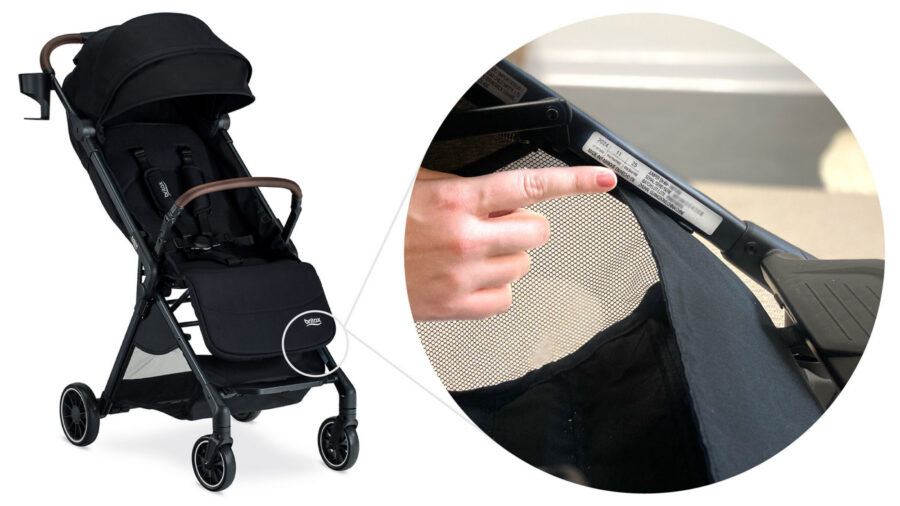 Hand pointing to the label on the inside of the stroller frame, at the front of the stroller, right above the storage basket.