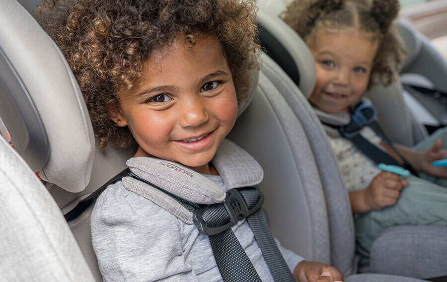 Two smiling young children in car seats.