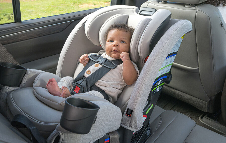 A baby in a rear-facing car seat in the back seat of a vehicle.