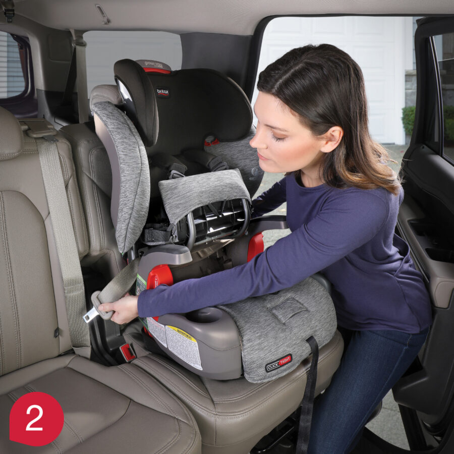 Mother demonstrating how to thread and buckle the vehicle seat belt