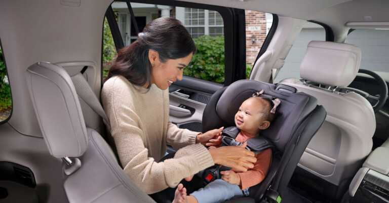 Similing child rear facing poplar car seat interaction with mom