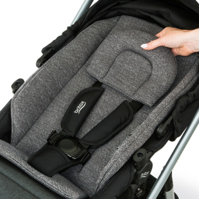 Placing a cushioned seat insert into a toddler stroller.