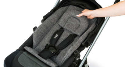 Placing a cushioned seat insert into a toddler stroller.