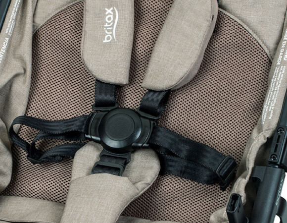 The seat back of a stroller with a 5-point harness, a section of mesh fabric, and the Britax logo on the harness pads.