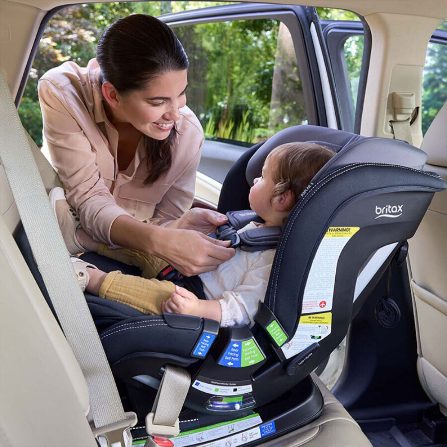 Someone adjusting the chest clip on a rear-facing car seat.