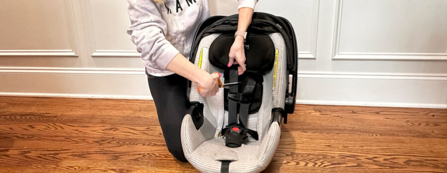 A woman cutting a car seat harness