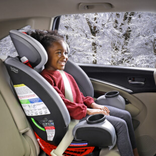 A child sitting in a forward-facing car seat.