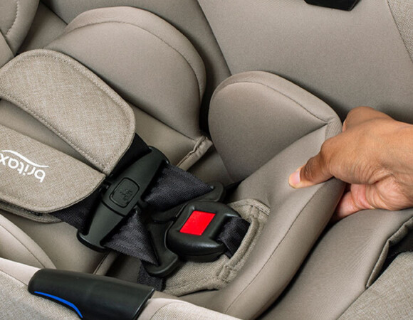 Someone squeezing infant car seat inserts to demonstrate softness.