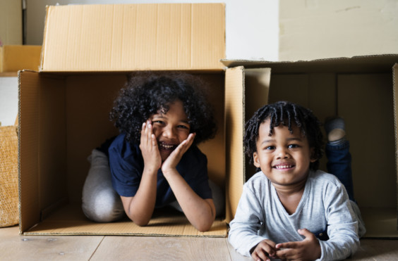 Two kids playing with moving boxes