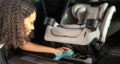 Wiping crumbs out from under a child’s car seat.