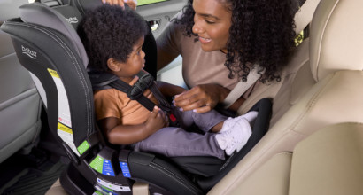 A male toddler in a rear-facing car seat with an anti-rebound bar.