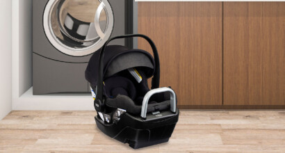 Raven Black infant car seat placed in front of a washing machine.