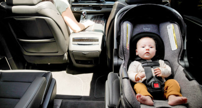 A baby in a rear-facing infant car seat in the back seat of a vehicle.